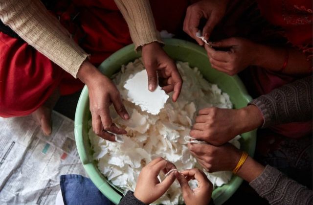 Las mujeres preparan el material para hacer compresas sanitarias.