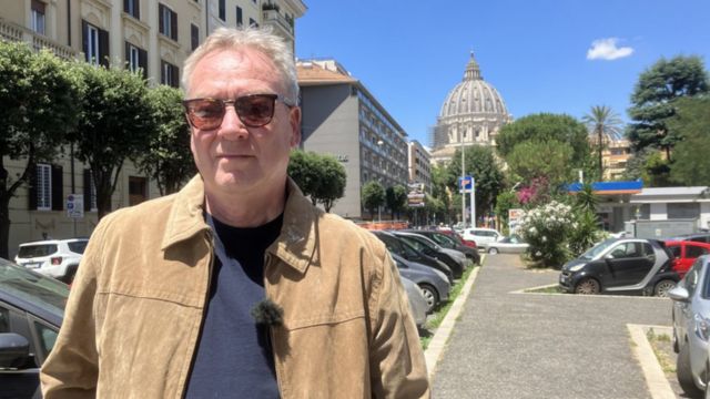 Color photograph shows a 65-year-old white man with sunglasses on a street in Rome