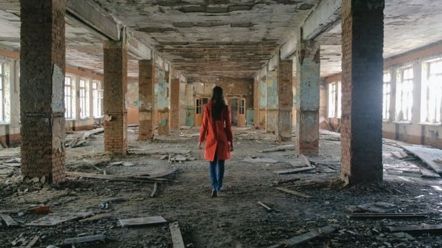 mujer en edificio de Siria