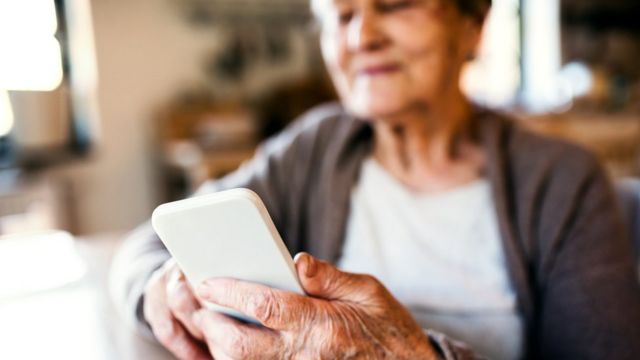 Una mujer mayor con un celular