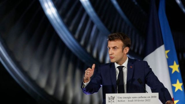 O presidente da França, Emmanuel Macron, um homem branco e jovem de terno em um palanque