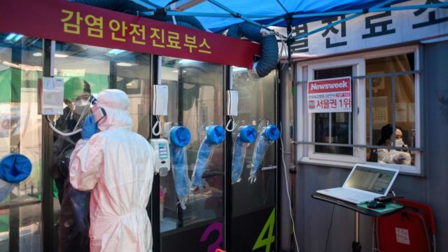 A man speaks to a nurse during a COVID-19 novel coronavirus test at a testing booth outside Yangji hospital in Seoul in March 2020