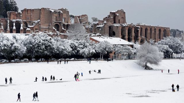 People walk during a heavy snowfall at the Circus Maximus in Rome