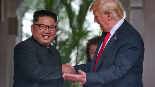Ким Чен Ын и Дональд Трамп пожимают руки и улыбаются