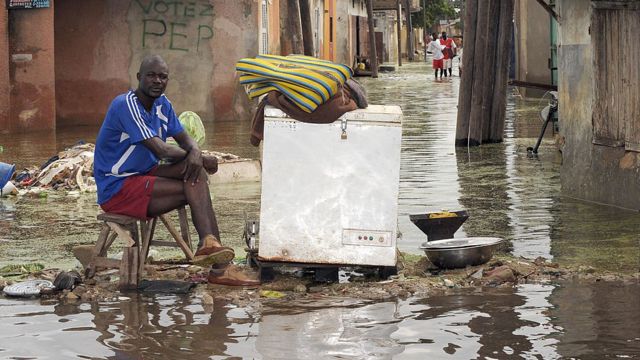 Un homme assis devant ses affaires dans une rue de la banlieue inondée en 2009