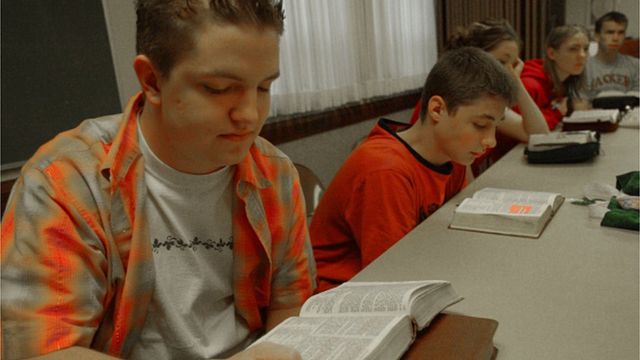 школяри читають Біблію