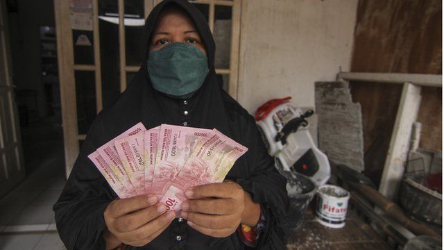 Warga menunjukkan uang Bantuan Sosial Tunai (BST) Kemensos di wilayah Bojong Pondok Terong, Depok, Jawa Barat, Kamis (22/07).