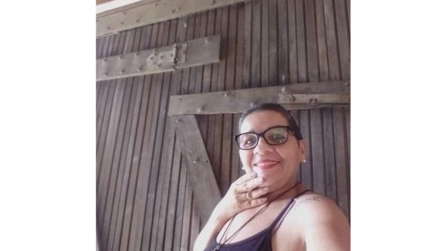 Severina sorri para selfie, em frente a portão de madeira