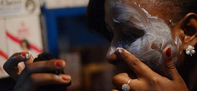 A beautician who works on Nairobi's River Road illustrates how to apply skin-lightening cream