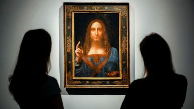 Personas posan junto a una pintura de Leonardo da Vinci titulada Salvator Mundi antes de ser subastada en Christie's en Nueva York.