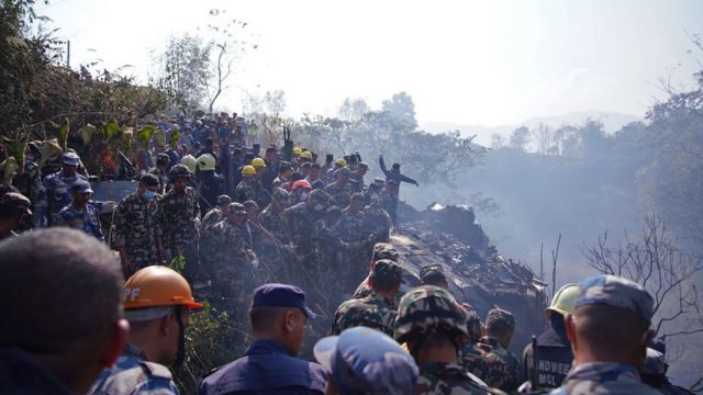 Rescuers gather at the plane crash site in Pokhara