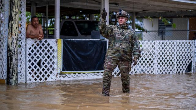 Żołnierz stoi na zalanym terenie w Puerto Rico.