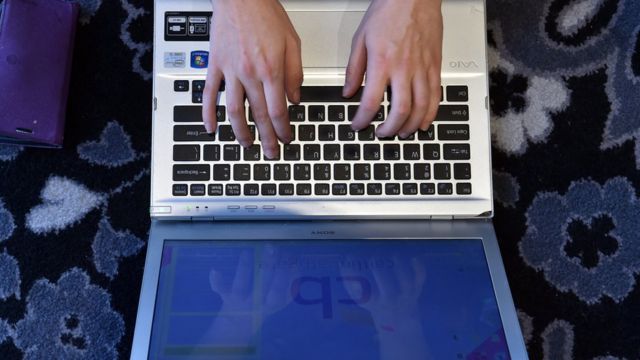 Manos sobre un teclado de computadora portátil.