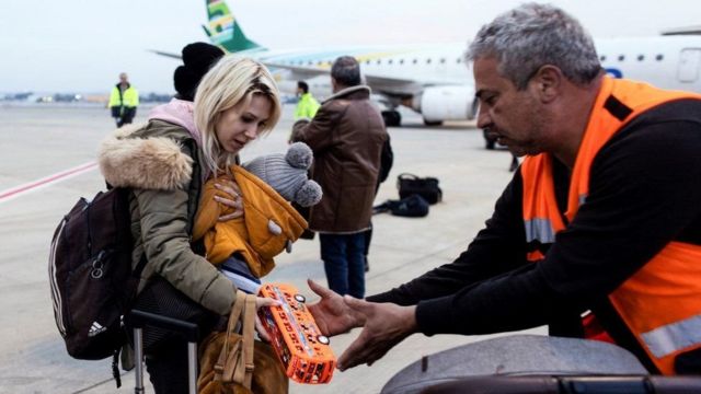 رجل اغاثة يستقبل لاجئة من أوكرانيا