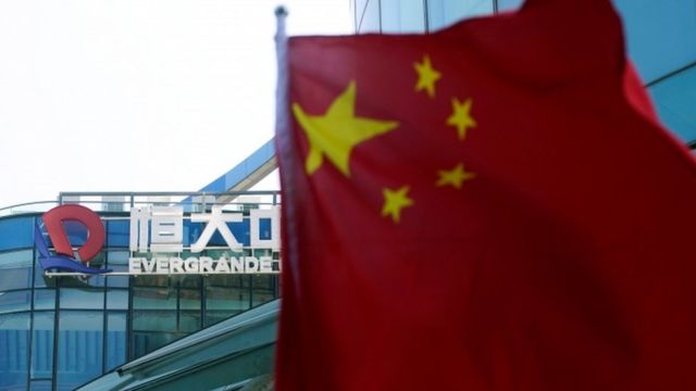 Chinese flag with Evergrande Center, Shanghai in background.