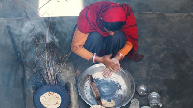 Mujer de país en desarrollo cocinando.