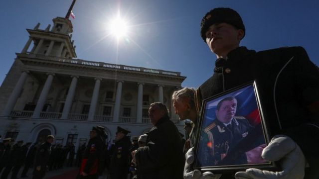 Soldado carrega foto de militar russo morto