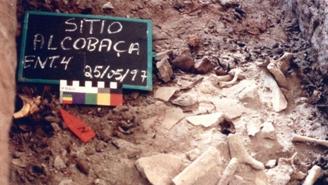 Placa em terreno arenoso traz anotação: Sitio Alcobaça