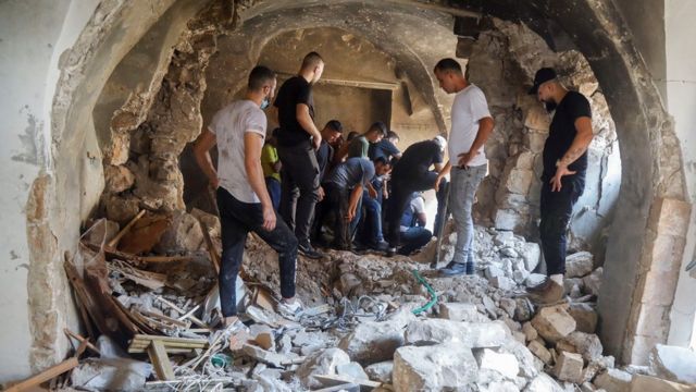 فلسطينيون في منزل دمرته إسرائيل في نابلس.