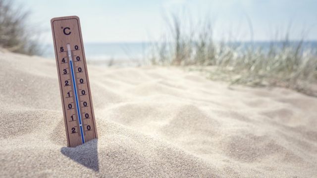 Termômetro em praia, mostrando temperatura alta
