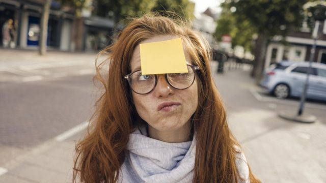 Woman on the street with a note on her forehead