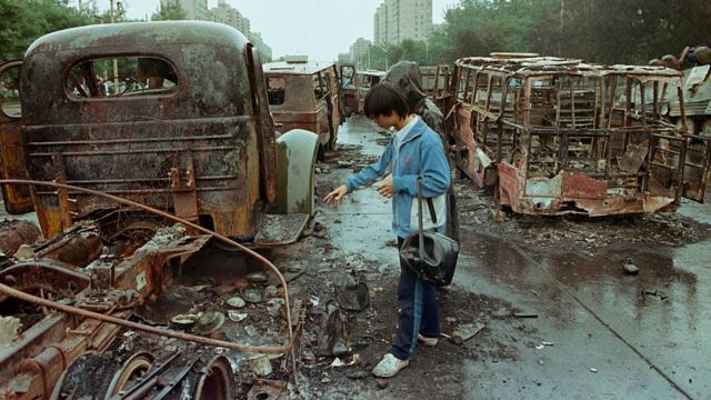 Un ciudadano chino observa los escombros de vehículos quemados tras los enfrentamientos en la Plaza de Tiananmen