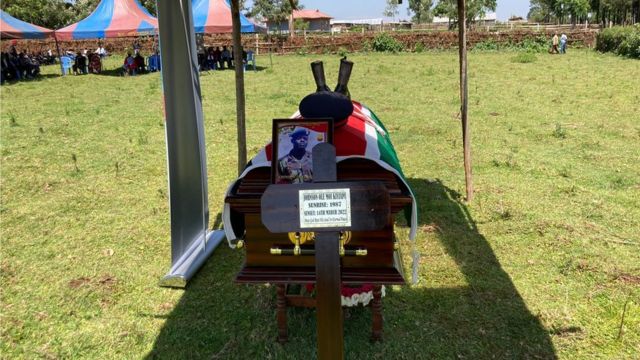 Coffin on Ole Kiyaipi with the Kenyan flag draped over it and a photo of him