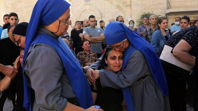 این دو خواهر راهبه دوقلو از بستگان قربانیان حمله اسرائیل به محوطه کلیسای ارتدوکس سنت پورفیریوس دلجویی می‌کنند