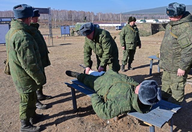 Servicemen assigned from the reserve during the detention of first aid as part of combat training in the field office on the territory of the district training center at the Peschanka training ground