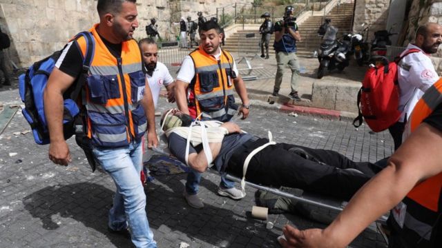 Palestinian medics carry a wounded man on a stretcher at the Lions' Gate of Jerusalem's Old City