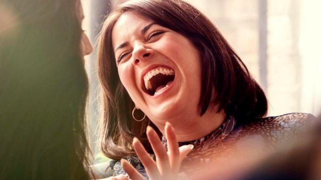 Una mujer riendo a mandíbula batiente
