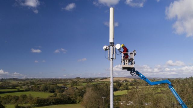 A worker installs a 5G antenna