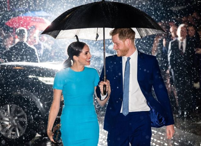 принц Гарри и Меган на улице под зонтиком