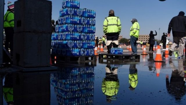 Workers in Houston pass out cases of water