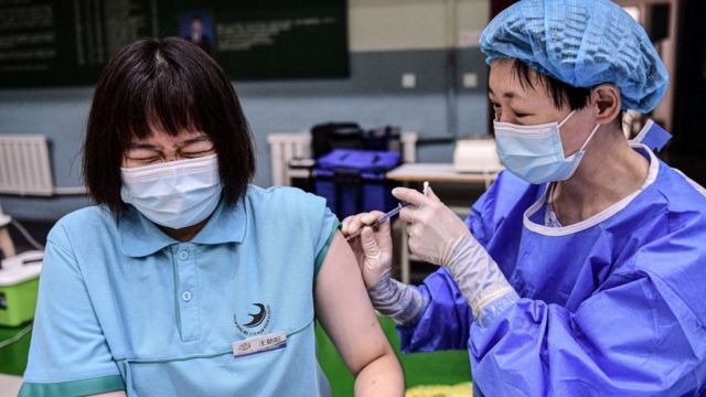 Một học sinh (bên trái) phản ứng khi tiêm vaccine Sinopharm Covid-19 tại một trường trung học ở Thẩm Dương thuộc tỉnh Liêu Ninh, đông bắc Trung Quốc vào ngày 28 tháng 7 năm 2021
