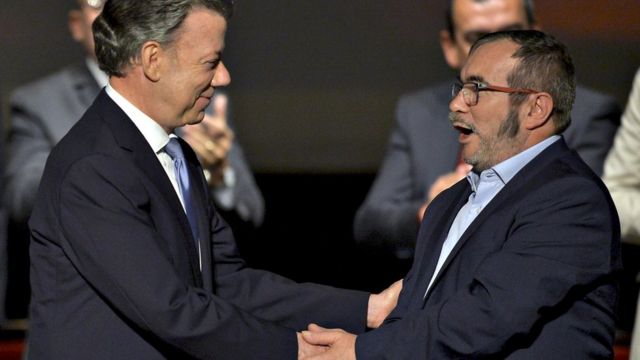 Juan Manuel Santos y Timochenko estrechándose de manos.