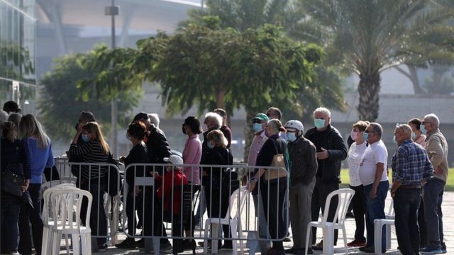 People wait in line to receive the first dose of Coronavirus vaccine in Tel Aviv