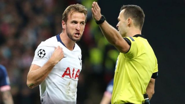 Jogador de futebol discute com o juiz em uma partida