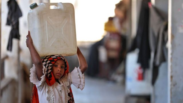 فتاة تحمل حاوية مياه على رأسها في مبنى مدرسة للنازحين اليمنيين الذين فروا من القتال بين المتمردين الحوثيين والقوات الحكومية المدعومة من السعودية ، في بلدة التربة في محافظة تعز اليمنية.