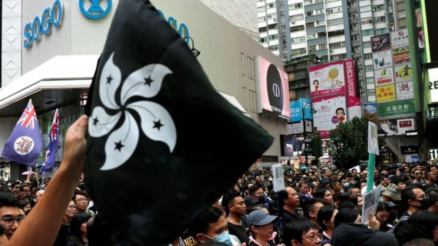 A protester holds a black Hong Kong flag during a rally to demand democracy in Hong Kong, 18 August
