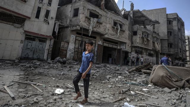 Um menino caminhando entre os escombros em Gaza