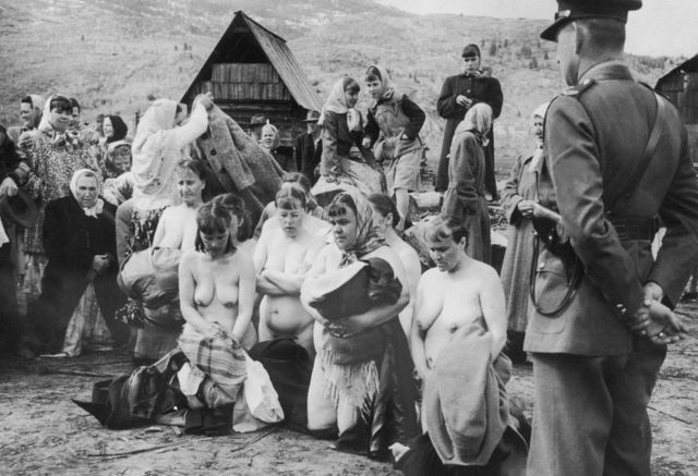 Policía observa mujeres vestidas y desnudas protestando.