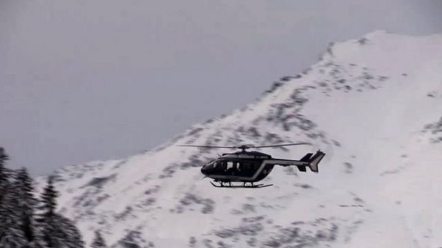 事故現場の上空を飛ぶ救助ヘリ(18日)