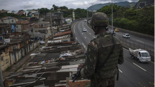 Militar observa a Cidade de Deus durante operação
