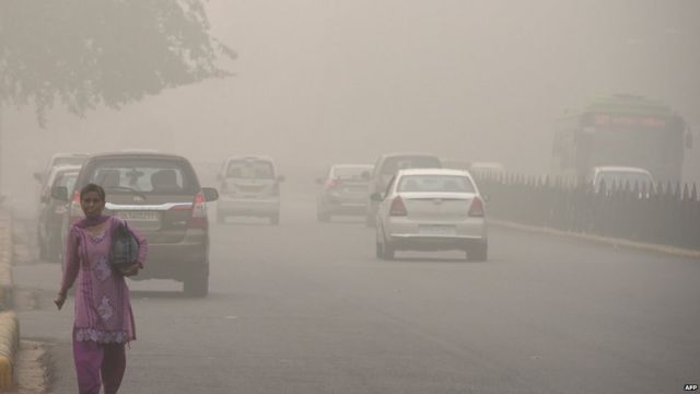 An Indian woman walks on a road during heavy smog conditions in New Delhi on November 7, 2017.