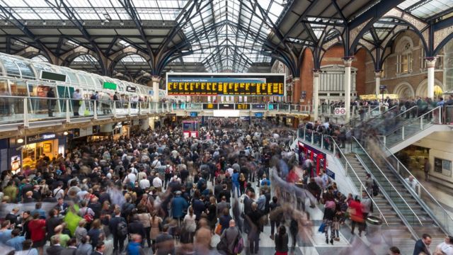 Una estación de trenes londinense llena de personas.
