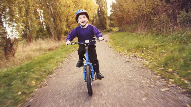 Niño montando bicicleta en el campo.