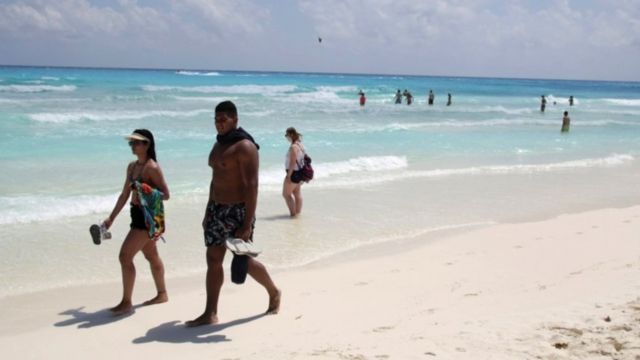 Casal caminhando na beira do mar em Cancún