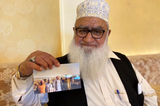 Haji Hanif showing a picture of a hunting party from the 1980s