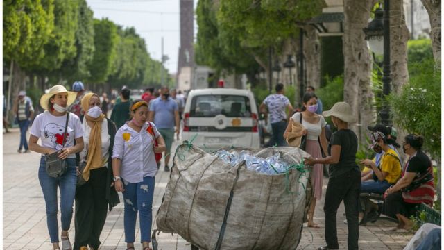 تونسيون يسيرون في شارع الحبيب بورقيبة وسط العاصمة التونسية